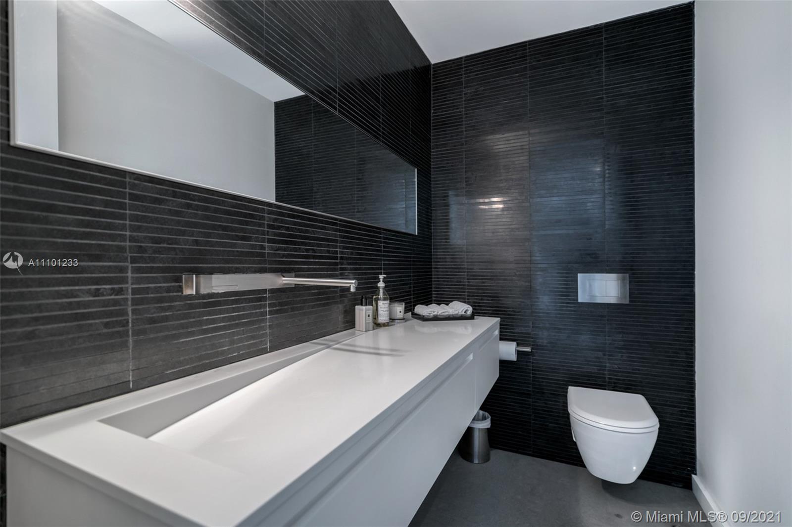 1236 Biscaya Drive Surfside, FL 33154 - Photo 23 of 40 a bathroom with a sink toilet and mirror