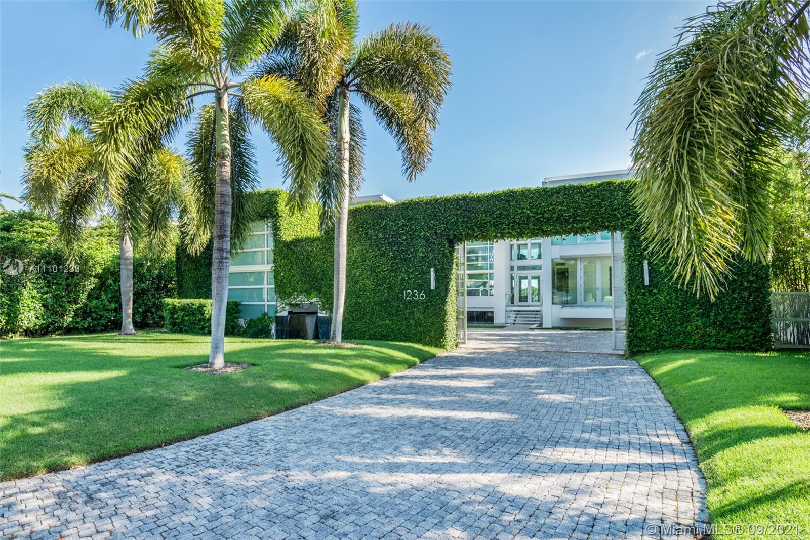 1236 Biscaya Drive Surfside, FL 33154 - Photo 32 of 40 a front view of a house with garden and trees