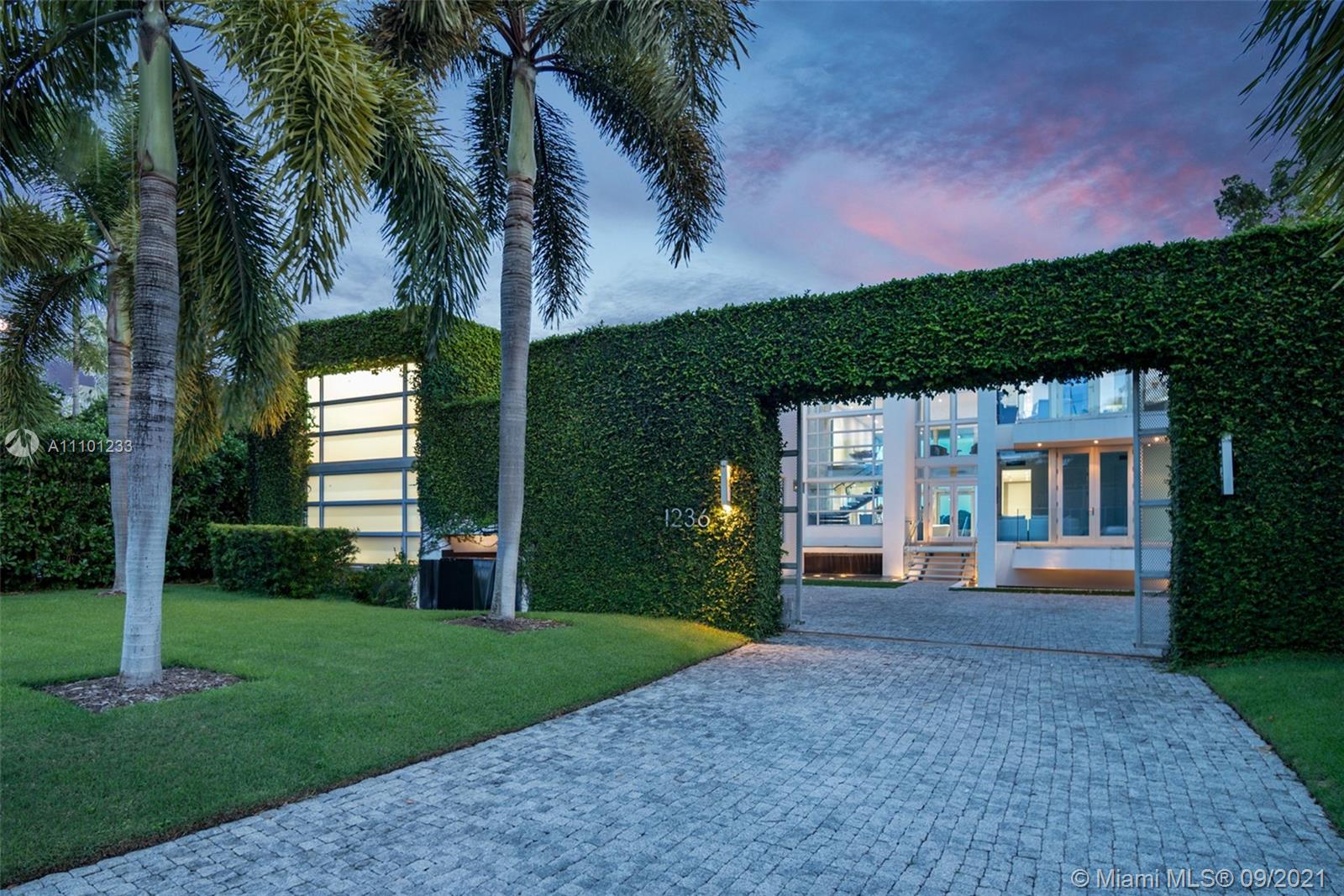 1236 Biscaya Drive Surfside, FL 33154 - Photo 7 of 40 a front view of a house with a garden and yard