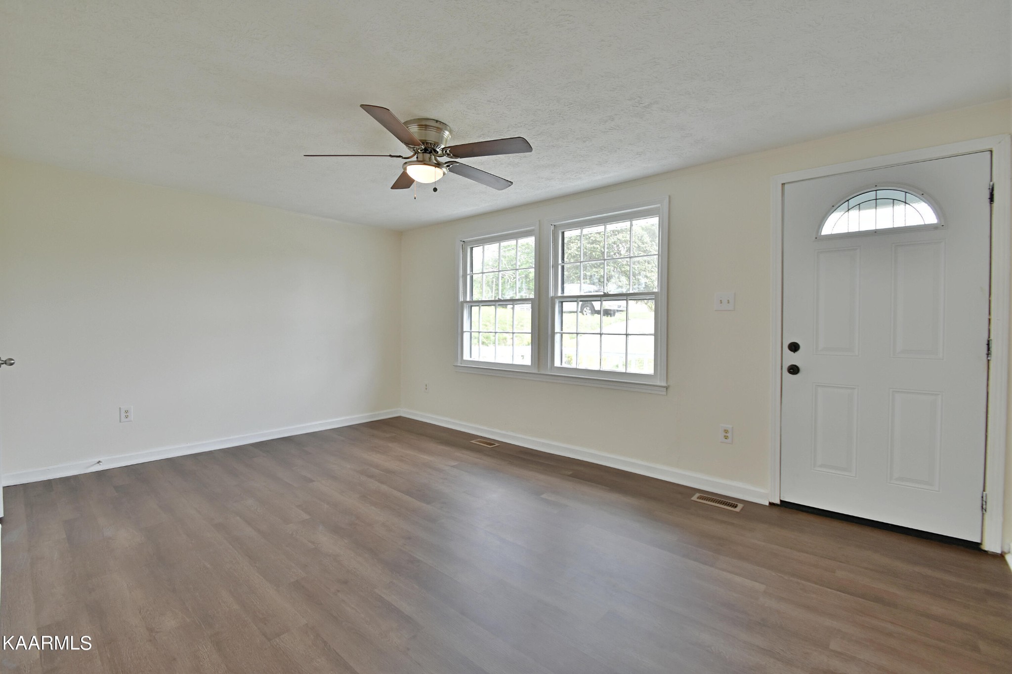 7715 Nicholas Drive Corryton, TN 37721 - Photo 4 of 16 an empty room with wooden floor closet and windows