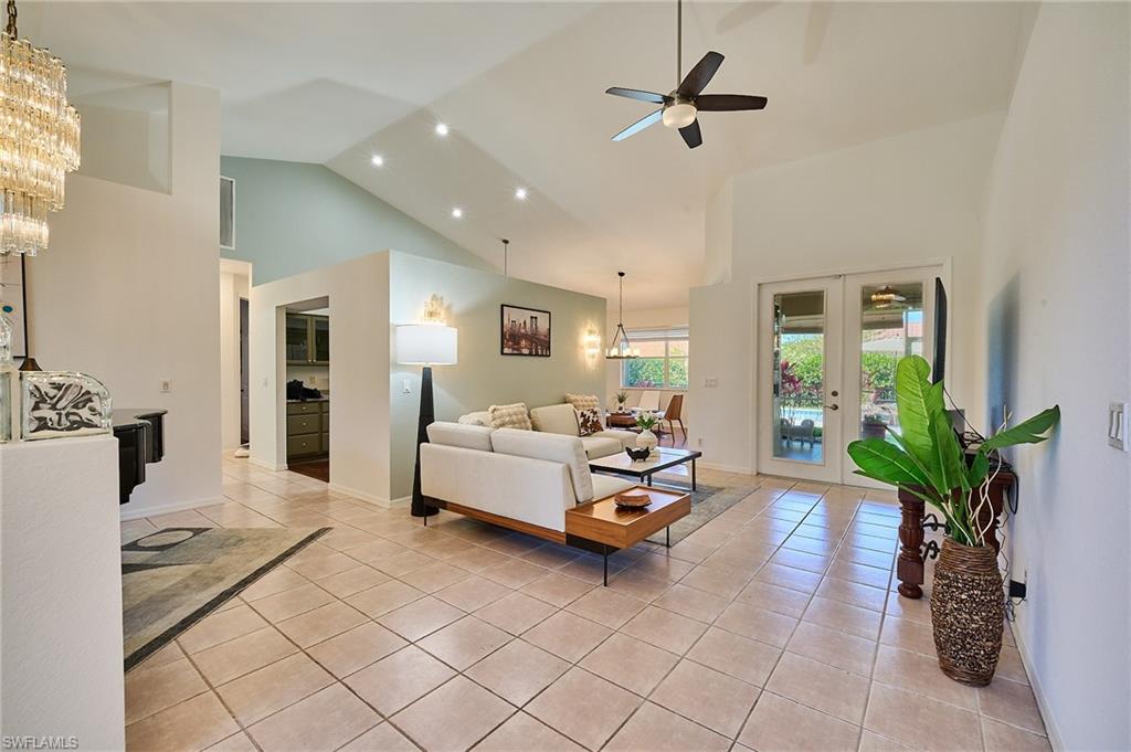 186 Muirfield Circle Naples, FL 34113 - Photo 9 of 36 a living room with furniture and a chandelier