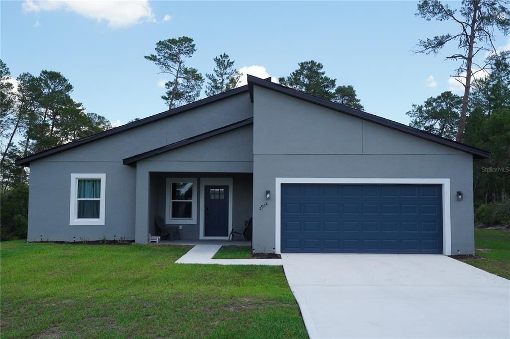 2914 Southwest 162nd Street Road Ocala, FL 34473 - Photo 40 of 47 a front view of a house with a yard and garage