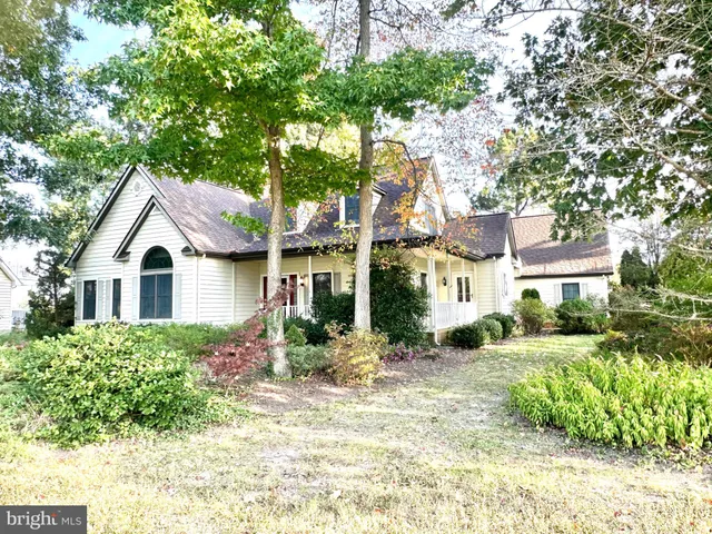 a front view of a house with a yard and potted plants