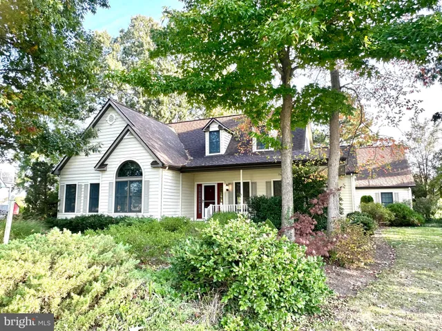 a front view of a house with a yard and trees
