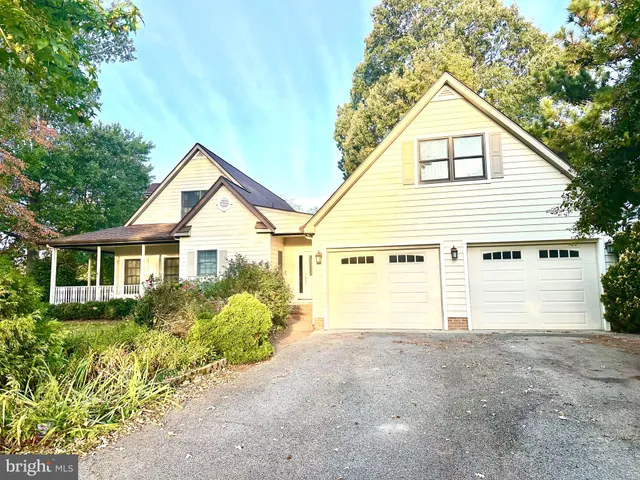 a view of a house with a yard and potted plants