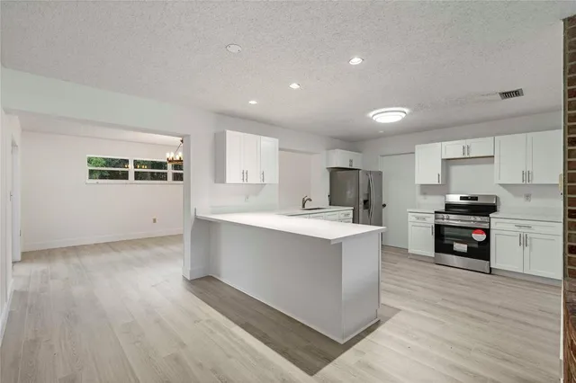 a kitchen with stainless steel appliances a refrigerator sink and cabinets