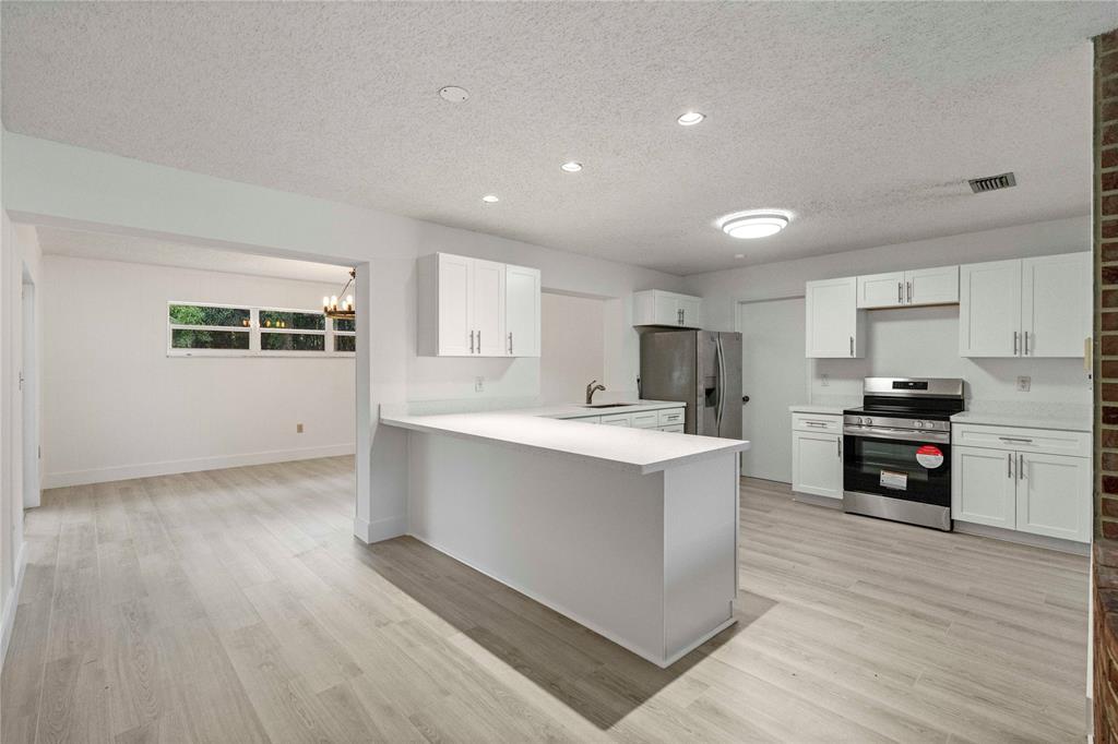 16900 Southwest 62nd Street Southwest Ranches, FL 33331 - Photo 16 of 48 a kitchen with kitchen island a sink dishwasher stove and oven with wooden floor