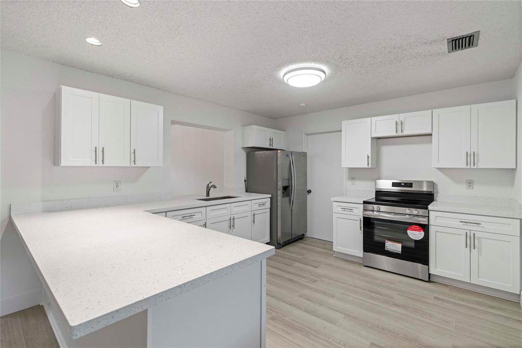 16900 Southwest 62nd Street Southwest Ranches, FL 33331 - Photo 20 of 48 a kitchen with granite countertop a stove and a refrigerator