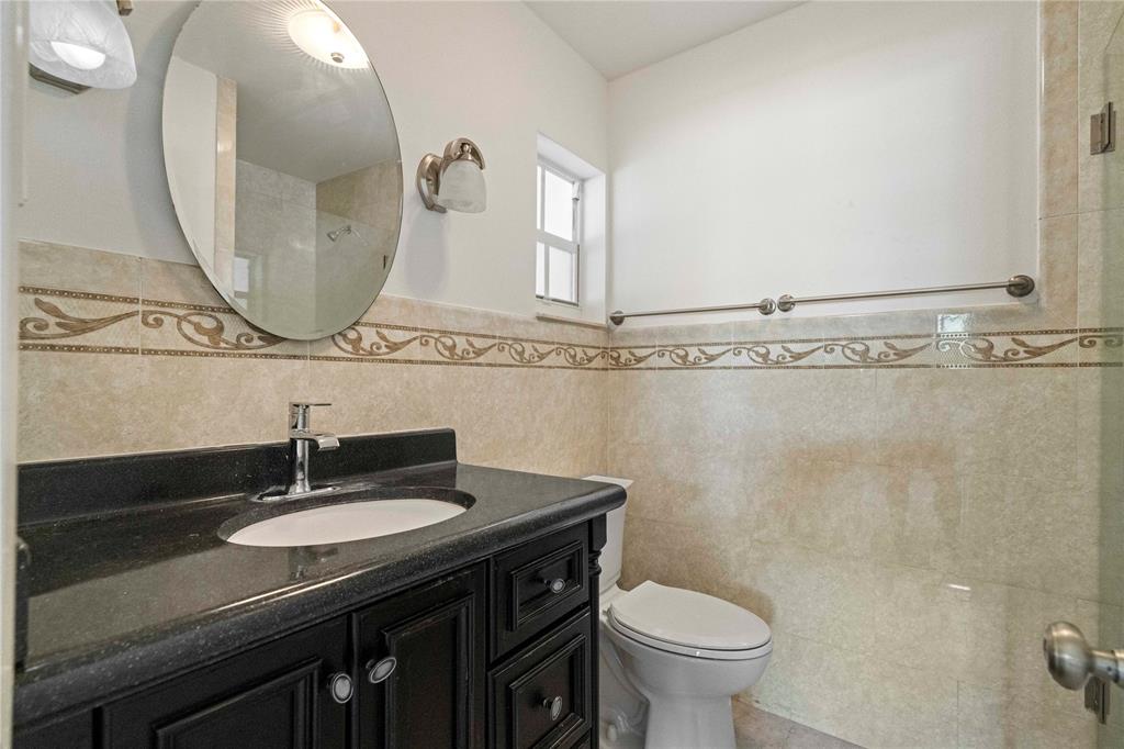 16900 Southwest 62nd Street Southwest Ranches, FL 33331 - Photo 47 of 48 a bathroom with a granite countertop toilet sink and mirror