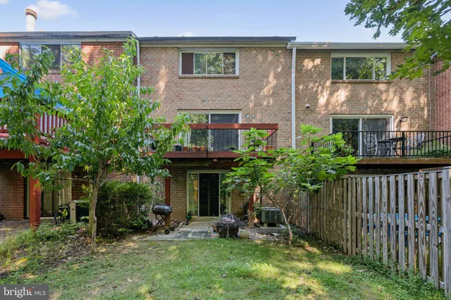 a view of a brick house with a yard and plants