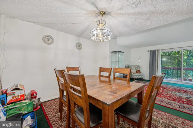 a view of a dining room with furniture a chandelier and a window
