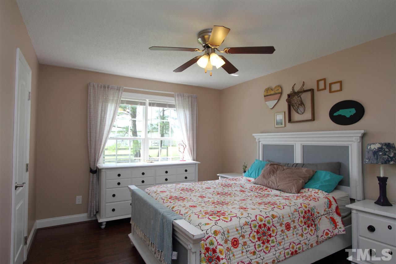4213 Bluewing Road Raleigh, NC 27616 - Photo 12 of 16 a bedroom with a bed and a chandelier