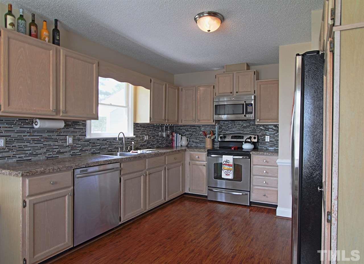 4213 Bluewing Road Raleigh, NC 27616 - Photo 7 of 16 a kitchen with granite countertop white cabinets and stainless steel appliances