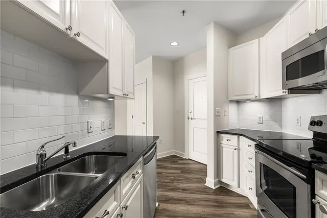 a kitchen with stainless steel appliances granite countertop a sink and a stove