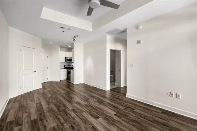 a view of kitchen and empty room with wooden floor