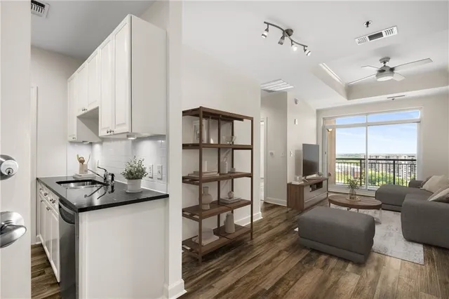 a kitchen that has a sink and a stove with wooden floor