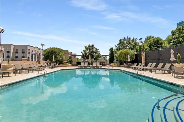 a view of swimming pool with outdoor seating and a garden