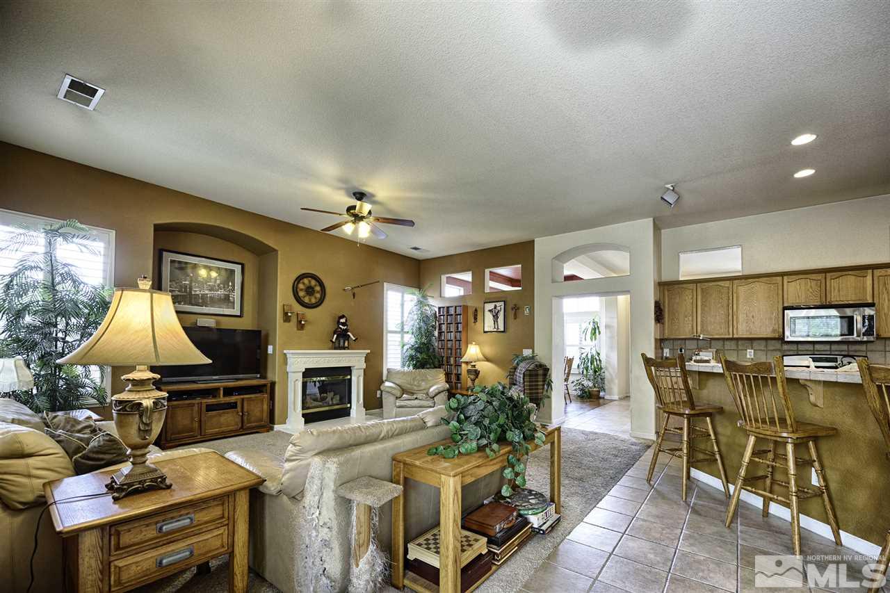1670 Caliterra Way Reno, NV 89521 - Photo 5 of 23 a living room with furniture a flat screen tv and a fireplace