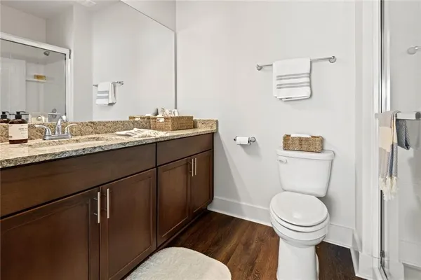 a bathroom with a granite countertop toilet sink and mirror