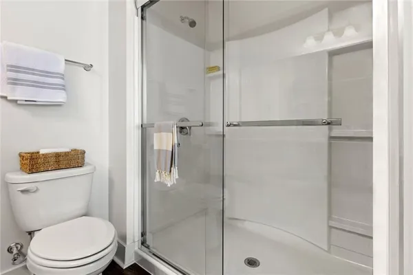 a white toilet next to a bathroom