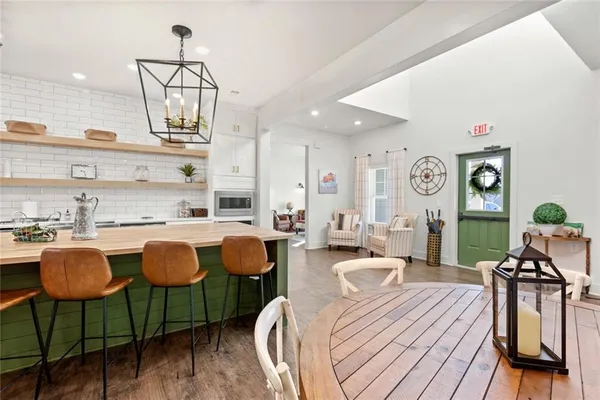 a very nice looking open dining room with kitchen island furniture and a chandelier