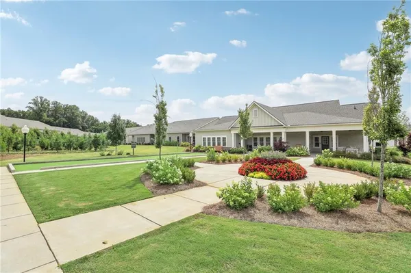a front view of a house with a yard and potted plants