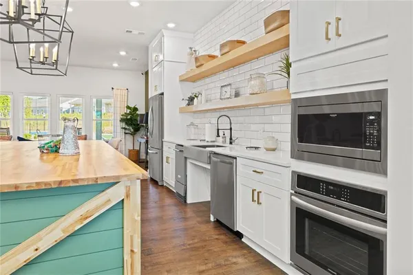 a kitchen with stainless steel appliances kitchen island granite countertop a stove a sink and a refrigerator