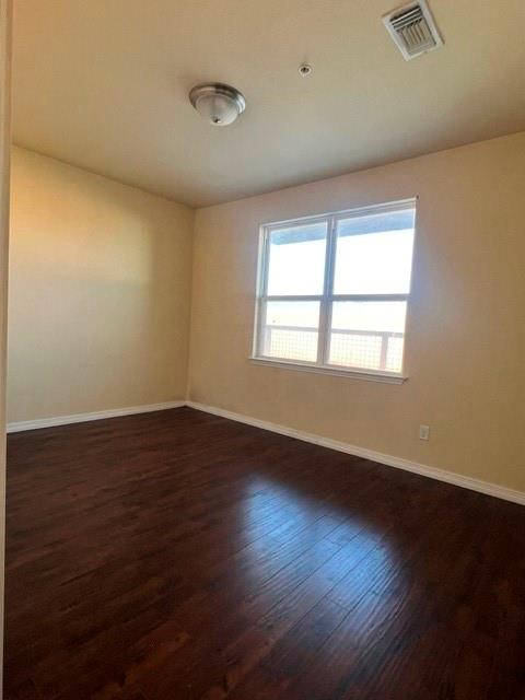 1100 West Trinity Mills Road, Unit 2001 Carrollton, TX 75006 - Photo 13 of 23 a view of an empty room with wooden floor and a window
