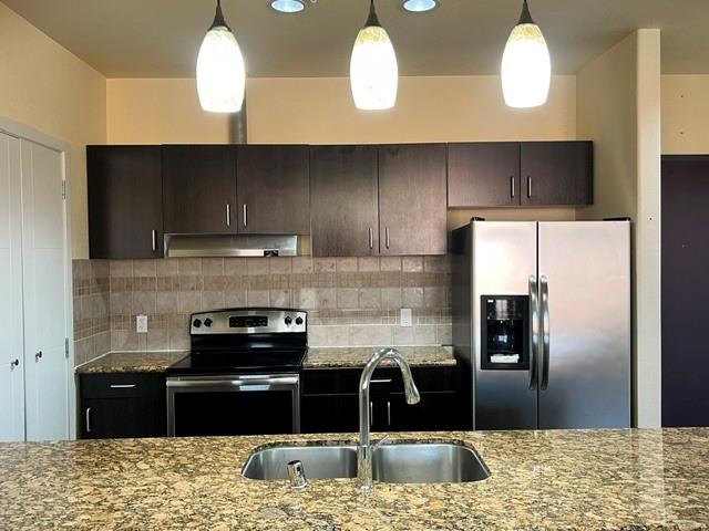 1100 West Trinity Mills Road, Unit 2001 Carrollton, TX 75006 - Photo 10 of 23 a kitchen with stainless steel appliances granite countertop a sink a stove and a refrigerator