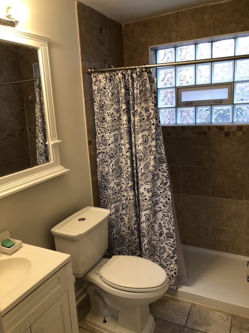 4313 South Harlem Avenue, Unit 3 Stickney, IL 60402 - Photo 7 of 8 a white toilet sitting next to a shower curtain
