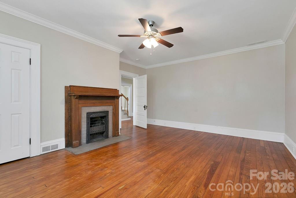 208 West Probart Street Brevard, NC 28712 - Photo 39 of 48 a view of an empty room with wooden floor and a fireplace
