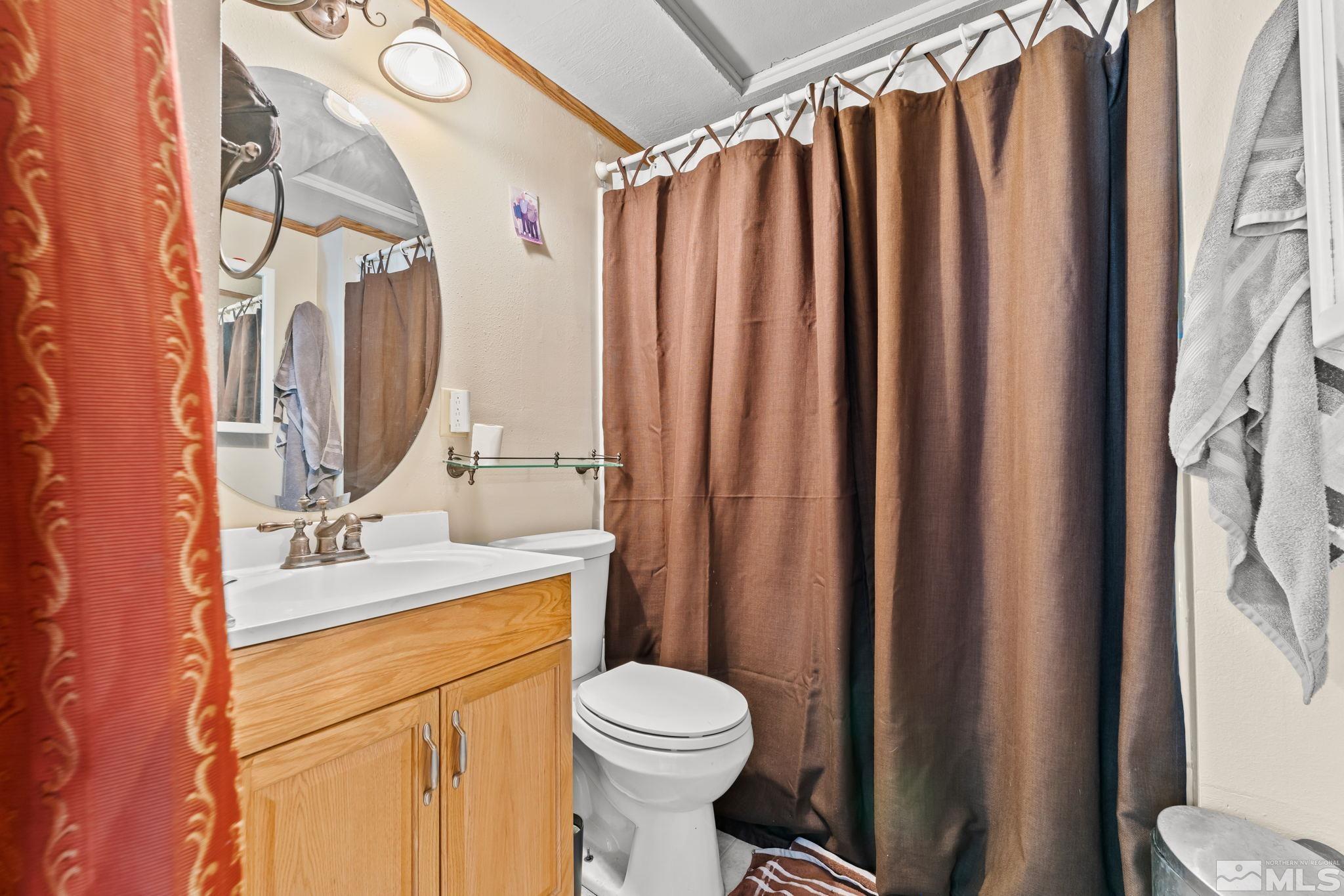 9295 Fremont Way Reno, NV 89506 - Photo 15 of 37 a bathroom with a sink a toilet and shower curtain