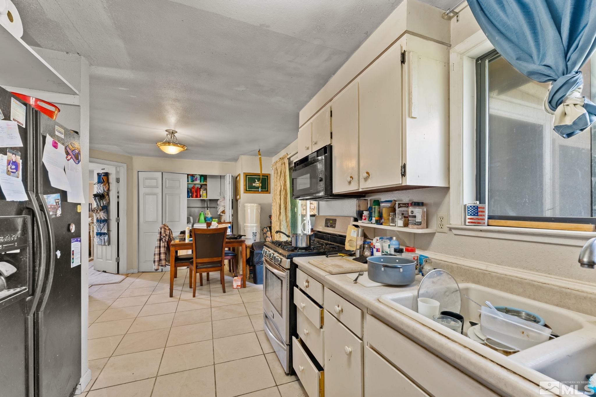 9295 Fremont Way Reno, NV 89506 - Photo 9 of 37 a kitchen with stainless steel appliances granite countertop a refrigerator and a sink