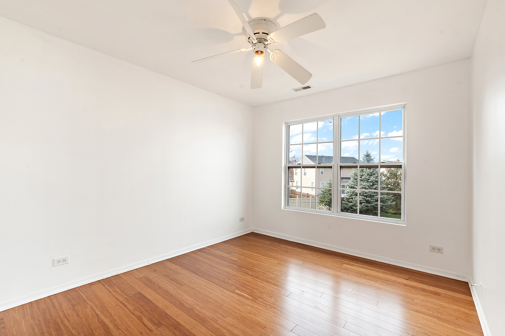1977 Crestview Circle, Unit 1973 Romeoville, IL 60446 - Photo 19 of 19 an empty room with wooden floor chandelier fan and windows