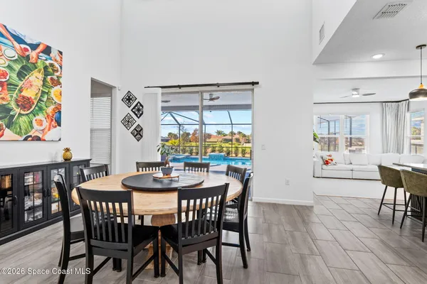a dining room with furniture a potted plant and wooden floor