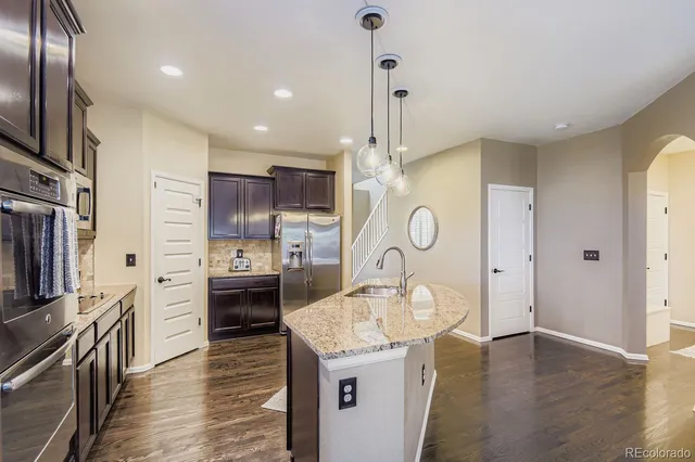 a kitchen with a refrigerator a sink and dishwasher a oven with wooden floor