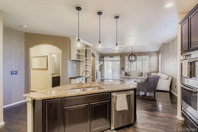 a kitchen with stainless steel appliances granite countertop a stove and a wooden floor