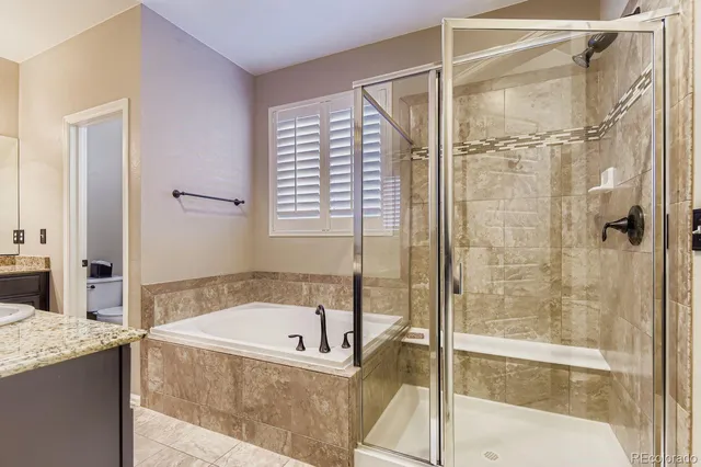 a bathroom with a granite countertop tub and a shower