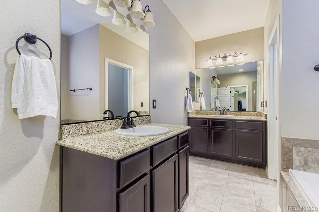 a bathroom with a granite countertop sink and a mirror