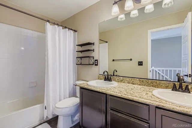 a bathroom with a granite countertop sink toilet and shower