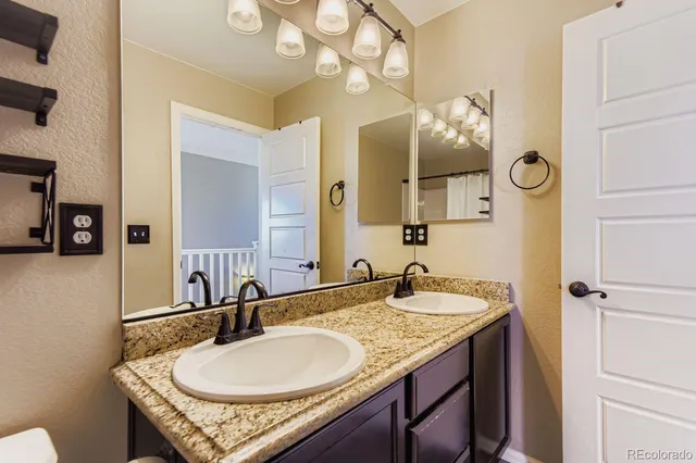 a bathroom with a granite countertop sink and a mirror