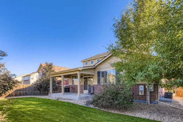 a front view of a house with a garden and trees