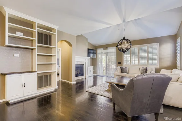 a living room with furniture wooden floor and a chandelier