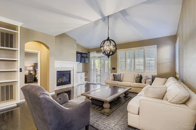 a living room with furniture chandelier and a fireplace