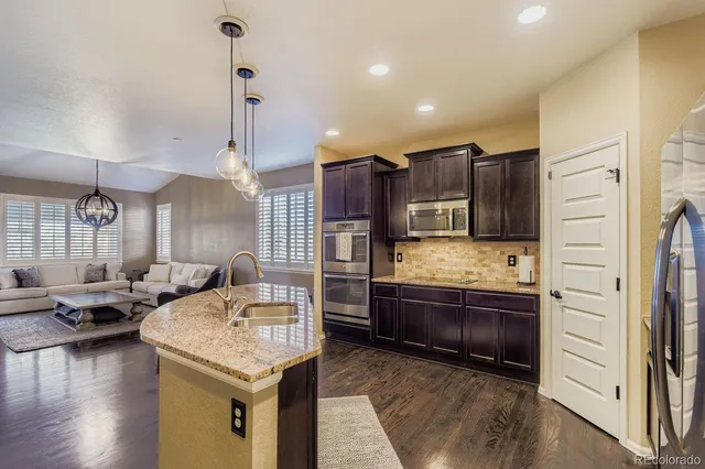 a kitchen with stainless steel appliances kitchen island granite countertop a refrigerator and a stove