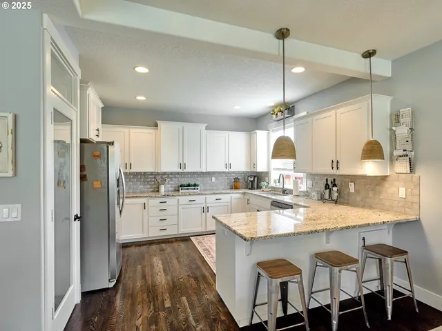 a kitchen with white cabinets and sink