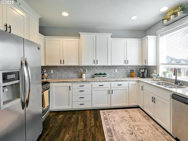 a kitchen with stainless steel appliances granite countertop a stove a sink and a refrigerator