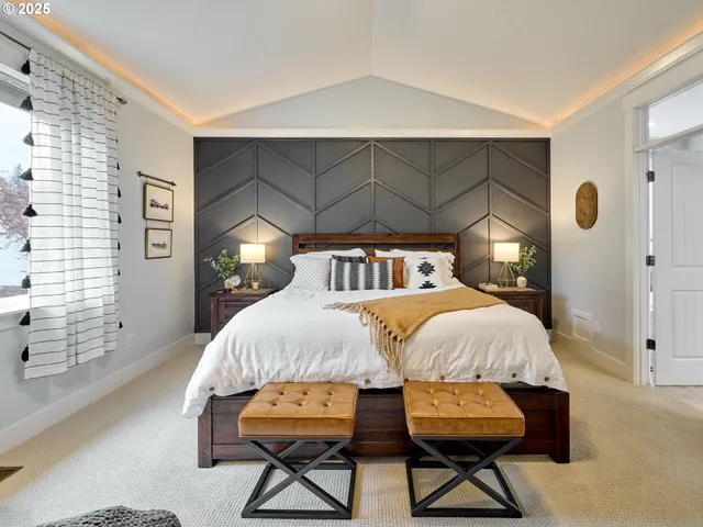 a bedroom with a bed a chair and potted plant on the table