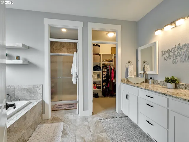 a bathroom with a granite countertop sink a mirror and a bathtub