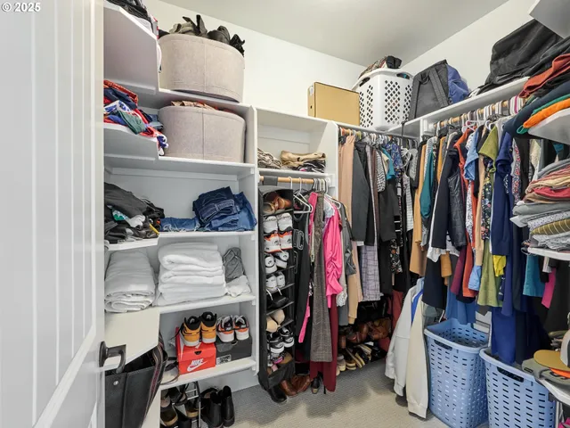 a view of walk in closet with clothes and shoes